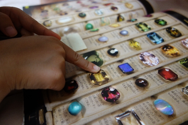 色石のカタログを指差す映像。イメージコンサルティングの技術によって、どんなアイテムでも迷いなく選ぶことができます